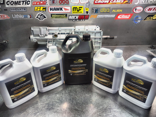 KCK RE44 transmission fluid in 2.5L and 5L alongside a Tremec T5 gearbox at Racing Solutions