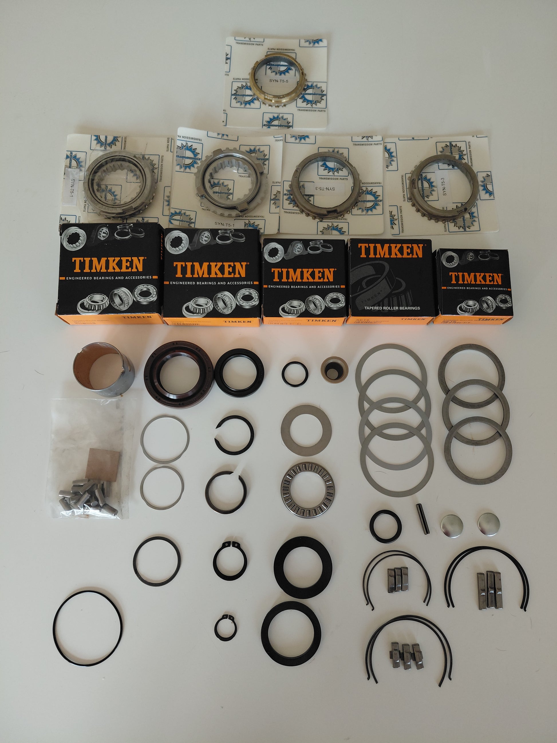 Tremec T5 World Class master rebuild kit laid out showing Timken bearings, carbon synchros, seals, shift keys and springs, shims, roll pins and clips